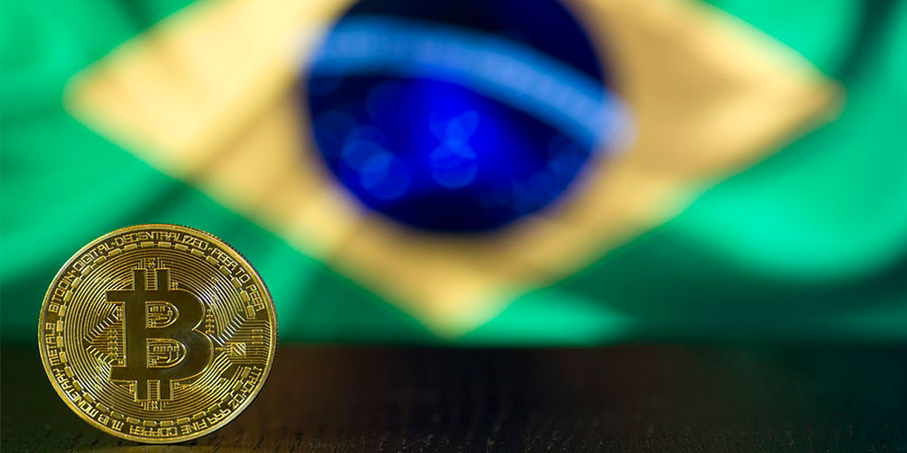 Moeda de Bitcoin e bandeira do Brasil no fundo