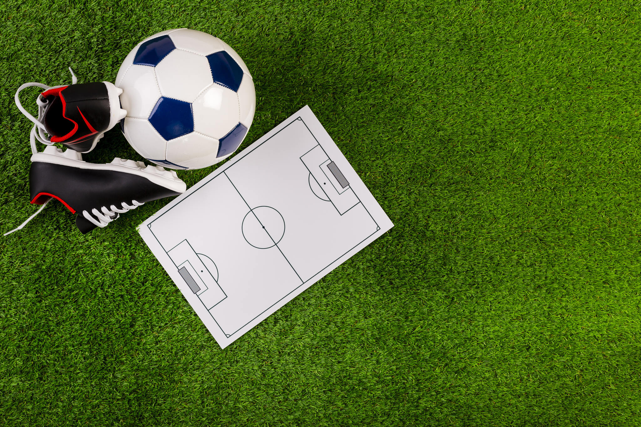 campo de futebol com uma quadra impressa com chuteira e bola
